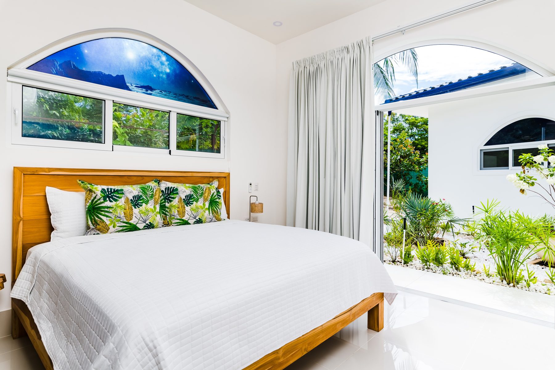 King bedroom with tropical accents and garden views at Villa Azueca