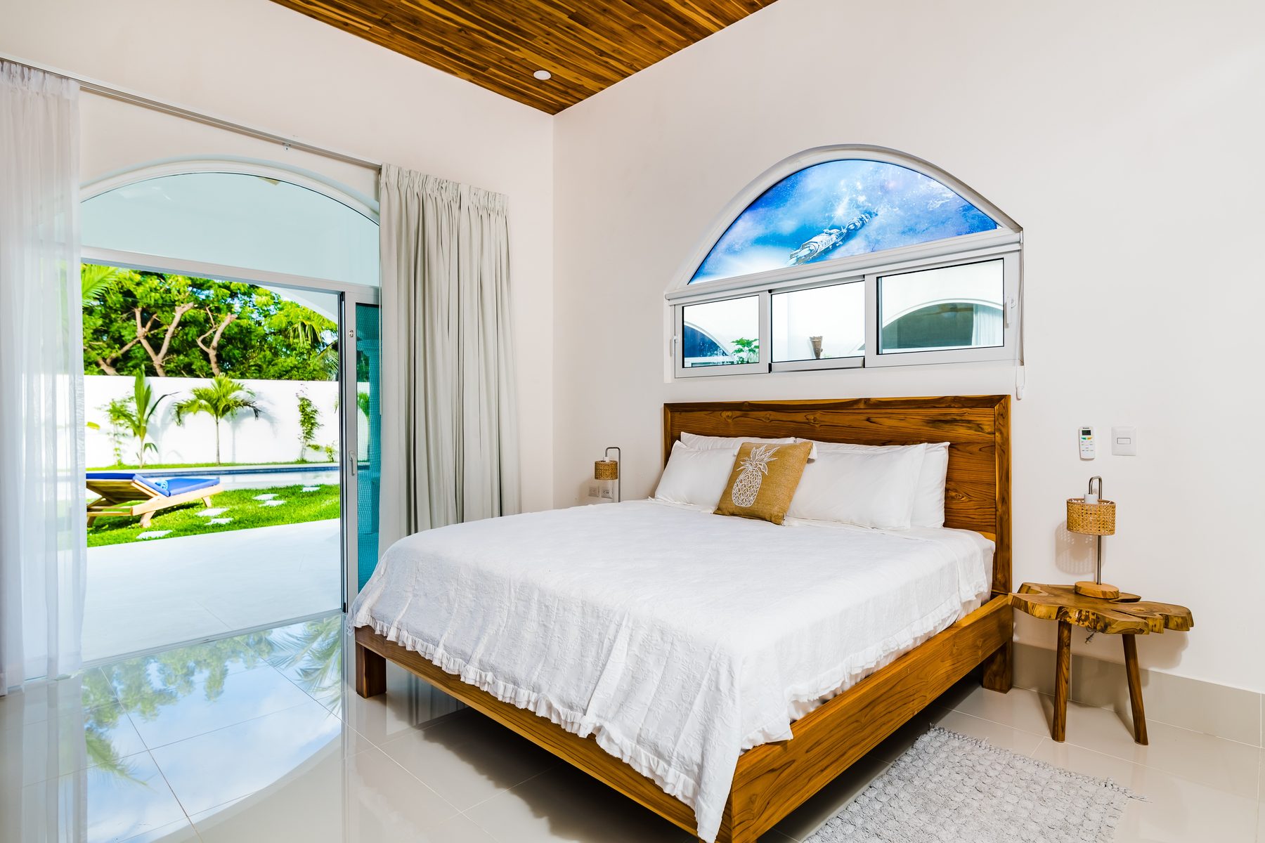Bright guest bedroom with teak bed frame at Villa Azueca