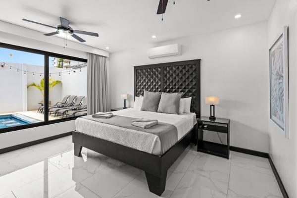 King bedroom with tufted headboard and ensuite at Villa Norma