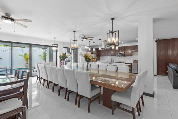 Long dining table with pool views at Villa Roberto