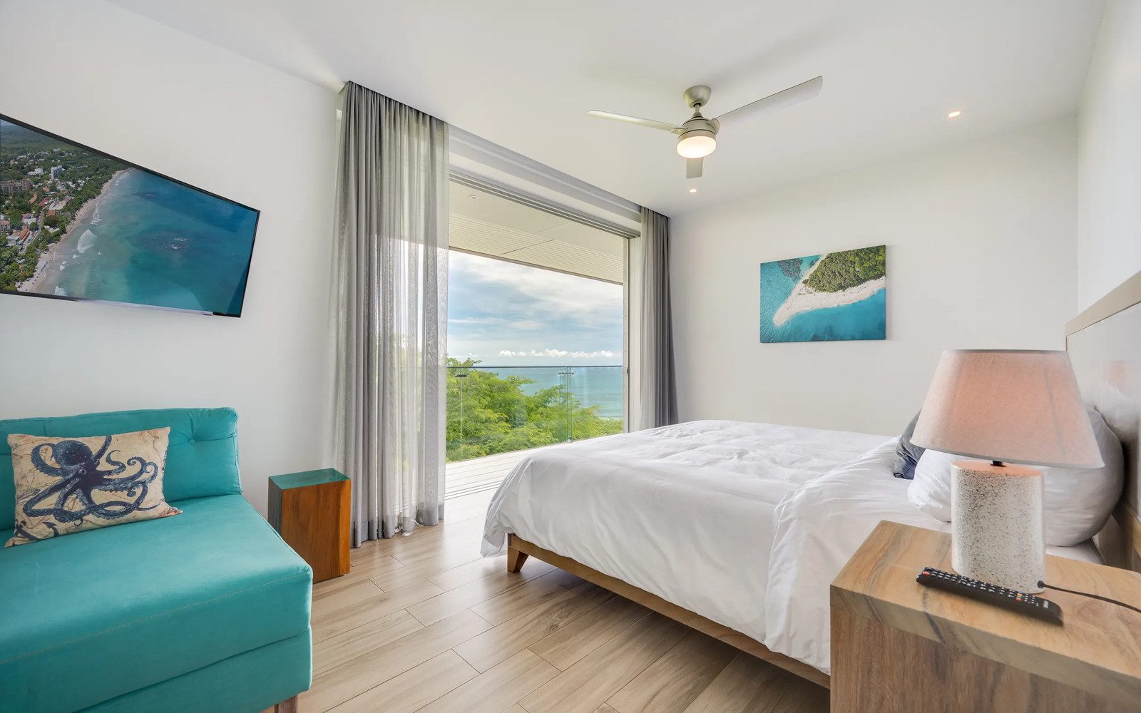Guest bedroom with ocean-view window at Villa Serenidad